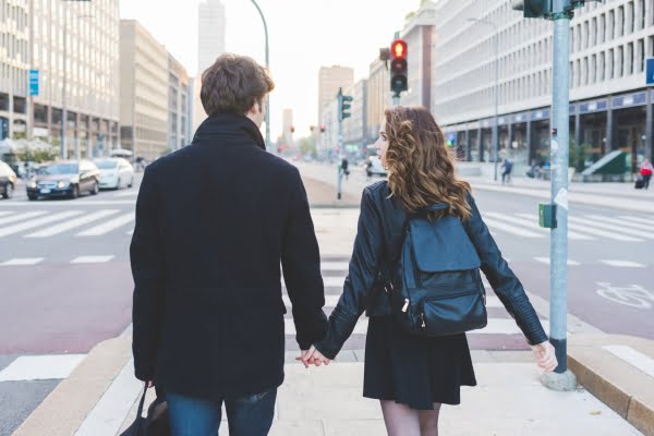 A-man-and-woman-walking-down-the-street-holding-hands-boulevard